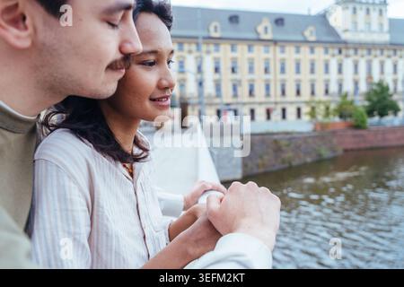 Junges, vielfältiges Paar, das in der Nähe der Glasfassade in der europäischen Stadt steht Stockfoto