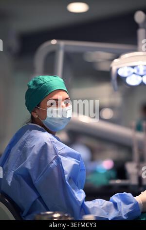 Zahnärztin mit chirurgischer Maske und Peeling in der modernen Zahnklinik lächelnd in die Kamera Stockfoto