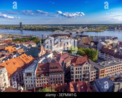 Blick aus der Vogelperspektive auf die Skyline der Altstadt von Riga mit dem Turm der Peterskirche und dem Fluss Daugava. Stockfoto