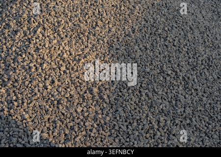 Detaillierter Kieshintergrund mit zerquetschtem Steinmaterial, das im Bau- und Straßenbau verwendet wird. Stockfoto