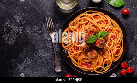 Spaghetti mit Fleischbällchen und Tomatensauce auf Steinhintergrund, Draufsicht Stockfoto