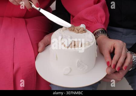 Finger mit rotem nagellack halten die Platte vorsichtig fest. Knusprige, goldbraune Stücke schauen von oben Stockfoto