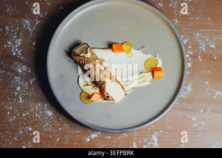Blick von oben auf Gourmet-Dessert auf grauem Teller Stockfoto