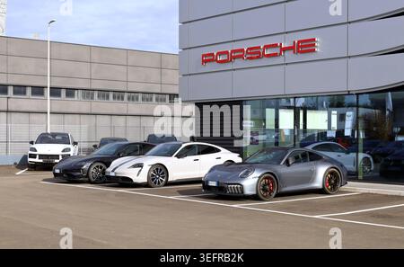 Udine, Italien. Dezember 2025. Porsche Carrera 911 GTS Seite an Seite mit zwei elektrischen PorscheTaycan außerhalb des offiziellen Händlerbetriebs. Stockfoto