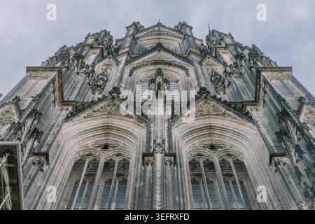 Der Blick auf die opulente Außenfassade des Kölner Doms in der westdeutschen Stadt erhebt sich im Sommer in Richtung blauer Himmel. Stockfoto