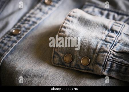 Nahaufnahme: Denim-Hemdmanschette mit Druckknöpfen aus Metall Stockfoto