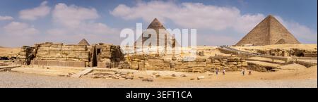 Das Gizeh-Plateau mit dem Pyramidenkomplex und der Großen Sphinx, Panoramablick mit Ausgrabungen in der Umgebung, Touristenwanderungen vor Ort, Ägypten. Stockfoto
