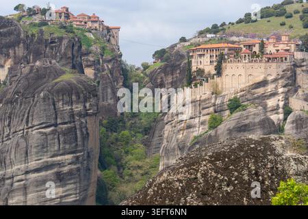Ein herrlicher Blick auf die Klöster Great Meteoron und Varlaam, die sich auf angrenzenden Felsengipfeln über dem tiefen Meteora-Tal thronen. Stockfoto