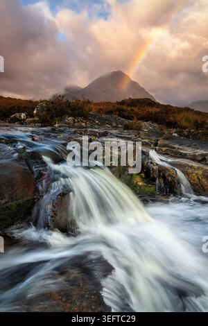Kaskade auf dem Fluss Etive im Herbst mit der Buachaille Etive Mor und Regenbogen im Hintergrund Stockfoto