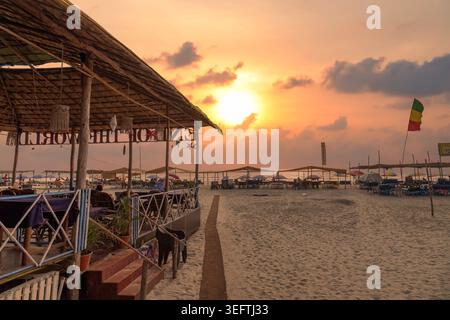 Sonnenuntergang über Strandhütten an der Baga Beach in Nord-Goa, Indien Stockfoto