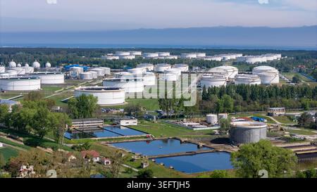 Hochwinkel-Luftaufnahme einer modernen industriellen petrochemischen Raffinerie und massiven Brennstofftanks in der Nähe einer Küste. Stockfoto