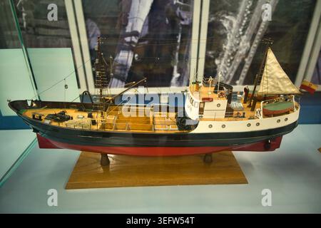 Detailgetreues Vintage-Modell-Fischerboot in Museumskoffer mit Holzständer und Rigging - Meeresfischmuseum in Świnoujście. Stockfoto
