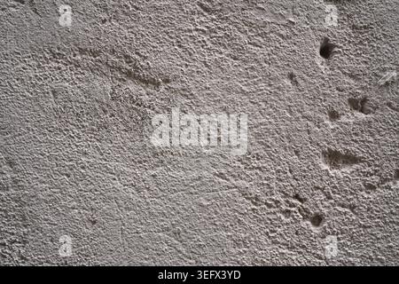 Rauer grauer Hintergrund mit Betonwandstruktur und altersgrauer, körniger Oberfläche und kleinen Löchern Stockfoto