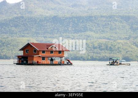 Großes oranges schwimmendes Floßhaus auf einem See mit Berghintergrund in Kanchanaburi Thailand Stockfoto