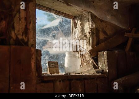Innenansicht einer Scheune, Fenster bedeckt mit staubigen Spinnweben. Selektiver Fokus Stockfoto