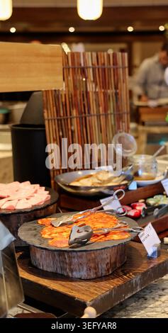 Verschiedene Aufschnitte einschließlich Chorizo und Schinken auf Schieferbrettern. Professionelles Buffet im Luxusrestaurant. Zange enthalten. Rustikales Holz und Bambus Stockfoto