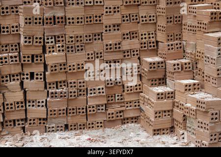 Große Stapel perforierter roter Tonziegel auf der Baustelle, Baumaterialien, Nha Trang, Vietnam Stockfoto