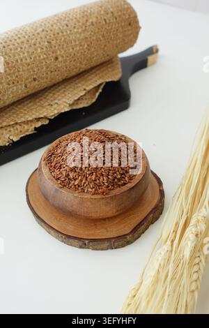 Flachssamen in Holzschüssel mit Vollkorn-Knäckebrot und Weizenstielen gesunde Pantry-Zutat Stockfoto