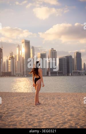 Frau im Badeanzug genießt Sonnenuntergang am dubai Marina Beach Stockfoto