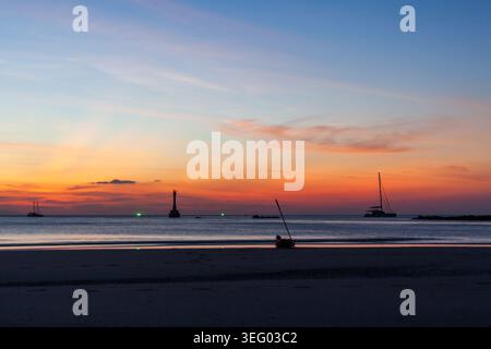 Koh Tarutao bei Sonnenuntergang. Ruhiges Meer mit Katamaran und Kajak. Marine Nationalpark in Thailand. Stockfoto