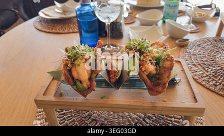 Gourmet Tempura Garnelen Tacos serviert auf Holzplatte Stockfoto