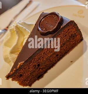 Wien, Österreich - 18. Januar 2026: Sacher Schokoladenkuchen mit Sahne im Café Sacher, Wien, Österreich Stockfoto