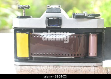 Manuelles Einlegen von Negativfilm auf eine einzelne Linse reflektiert in der hinteren Abdeckung Stockfoto