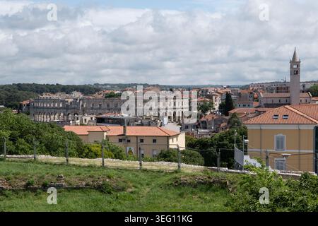 Erhöhter Panoramablick auf das antike Amphitheater der römischen Arena, umgeben von der Skyline der Altstadt und historischen Gebäuden in Pula Kroatien. Pula Croati Stockfoto
