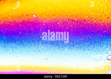 Nahaufnahme der schillernden Seifenblasenoberfläche mit einem Spektrum von hellen Farben und fließenden Bewegungen Stockfoto