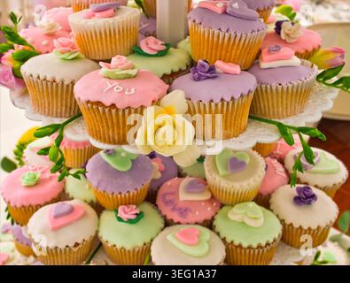 Hochzeitstorte bestehend aus Feenkuchen oder Cupcakes mit Herzen und Paspelbotschaften. Stockfoto