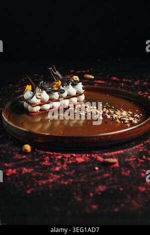 Luxuriöses Dessert mit Schokoladensoße und Garnitur auf dunklem Hintergrund Stockfoto