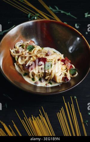 Köstliches Pastagericht in einer Holzschale, garniert mit Gemüse und roten Tomaten Stockfoto