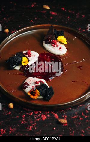Nahaufnahme eines raffinierten Desserts auf dunklem Teller Stockfoto