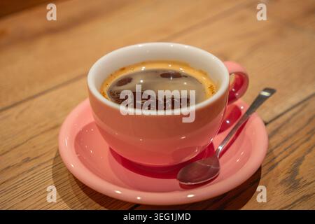 Grüner Matcha-Tee in rosafarbener Porecelain-Tasse auf dem Tisch im Café in Japan. Stockfoto