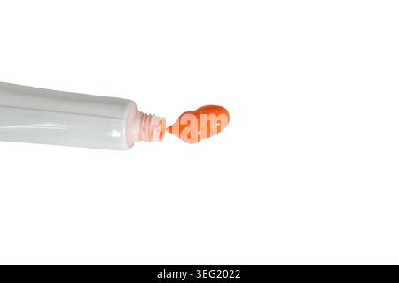 Tropfen von orangefarbener Aquarellfarbe und Pinsel isoliert auf weißem Hintergrund. Stockfoto