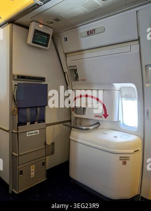 Eine Notausgangstür in der Flugzeugkabine einer Boeing 777-200 er von Thai Airways. Stockfoto