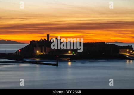Peel Castle Ruinen Silhouette bei Sonnenuntergang auf St Patrick's Isle, Peel, Isle of man, British Isles. Stockfoto