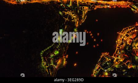 Baan Rak Thai Village bei Sonnenuntergang Reflektionen von Häusern und Restaurants entlang des Sees in chinesischer Architektur mit bunten Lichtern säumen das Wasser Stockfoto