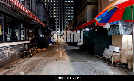 Ein ruhiger nächtlicher Blick auf eine Gasse auf dem Namdaemun Market, Seoul, Südkorea, mit farbenfrohen Markisen und geschlossenen Verkaufsständen vor dem Hintergrund von Illumi Stockfoto
