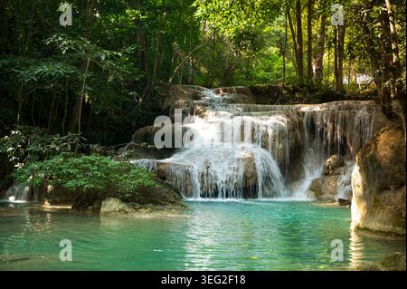 Tropische Kaskaden des Erawan Wasserfalls im Erawan Nationalpark, Kanchanaburi, Thailand, fließen in türkisfarbene Pools, umgeben von üppigem Dschungel und vor Stockfoto