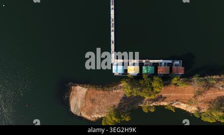 Luftaufnahme mit farbenfrohen schwimmenden Kabinen, die durch einen Pier am Reservoir verbunden sind Stockfoto