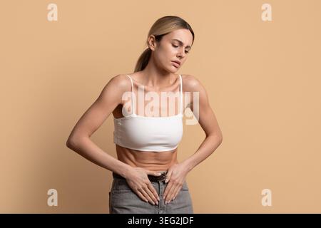 Junge Frau mit Bauchschmerzen und Menstruationskrämpfen Stockfoto