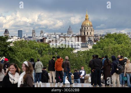 Die Menschenmassen in Trocadéro sehen die Skyline von Paris mit Les Invalides und dem Panthéon nach Regen in Paris, Frankreich. Stockfoto
