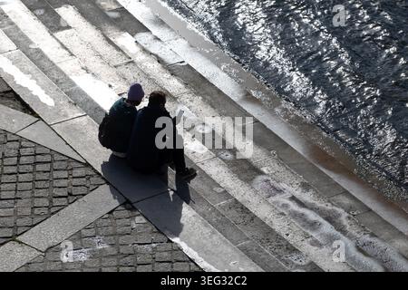 Paare sitzen auf den Stufen am Fluss neben der seine in der Nähe des Eiffelturms in Paris, Frankreich. Stockfoto