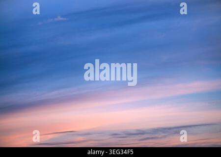 Pastellfarbener Sonnenuntergangshimmel mit weichen Wolken in der Dämmerung über einem ruhigen Horizont, Blick aus einem niedrigen Winkel Stockfoto