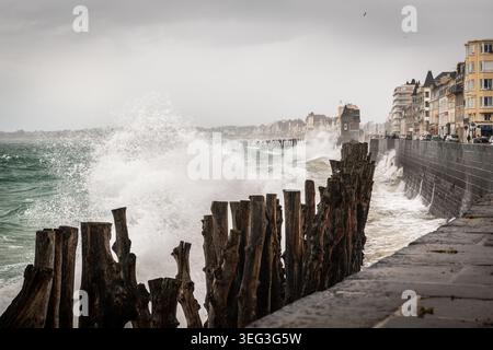 Saint-Malo, Frankreich - 10. August 2018: Eine massive stürmische Welle stürzt mit verwitterter Holzpalisade im Vorfeld gegen den Sankt-Malo-Meereswall Stockfoto