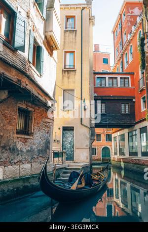 Gondel auf einem schmalen Kanal zwischen alten Gebäuden in Venedig, Italien. Reisekonzept. Stockfoto