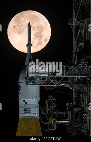 Der Vollmond ist hinter der Rakete Artemis II Space Launch System (SLS) der NASA und dem Orion-Raumschiff zu sehen, die am Sonntag, den 1. Februar 2026, im Kennedy Space Center der NASA in Florida auf einem mobilen Trägerraketen am Launch Complex 39B stehen. Der Artemis-II-Testflug der NASA wird bis spätestens April 2026 Kommandeur Reid Wiseman, Pilot Victor Glover und Missionsspezialistin Christina Koch von der NASA und Missionsspezialist Jeremy Hansen von der kanadischen Raumfahrtbehörde CSA um den Mond und zurück zur Erde bringen. Eine optimierte Version eines Originalbildes der NASA. Quelle: NASA/JKraus Stockfoto
