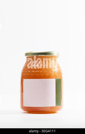 Orangenmarmelade in Glasgefäß mit natürlichem Thymianhonig mit strukturierter Oberfläche. Der Metalldeckel verschließt den Behälter fest. Modelletikett leer, bereit für individuelles Branding. Stockfoto