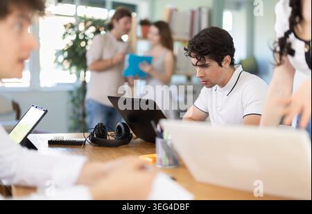 Mitarbeiter, die im Büro mit Laptops und Papierdokumenten arbeiten Stockfoto